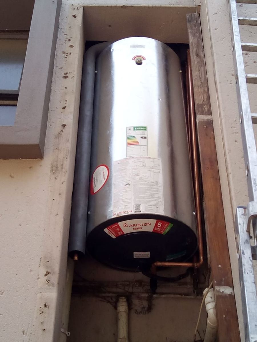 New Ariston 150 litre vertical geyser installed in an outside plumbing duct with copper pipework